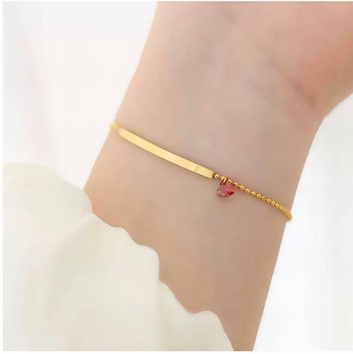 Pulsera barra dorada con dije de corazón - puesta en muñeca